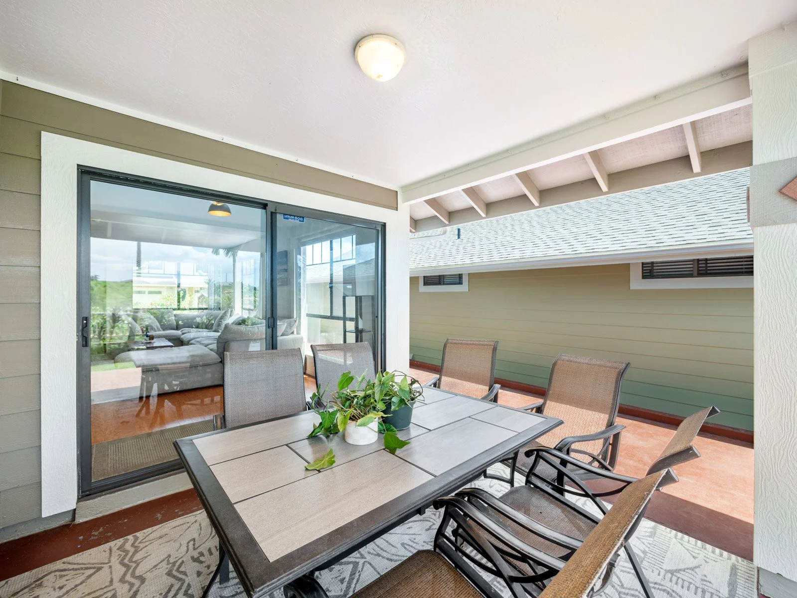 Covered lanai with dining set and open slider to the living room