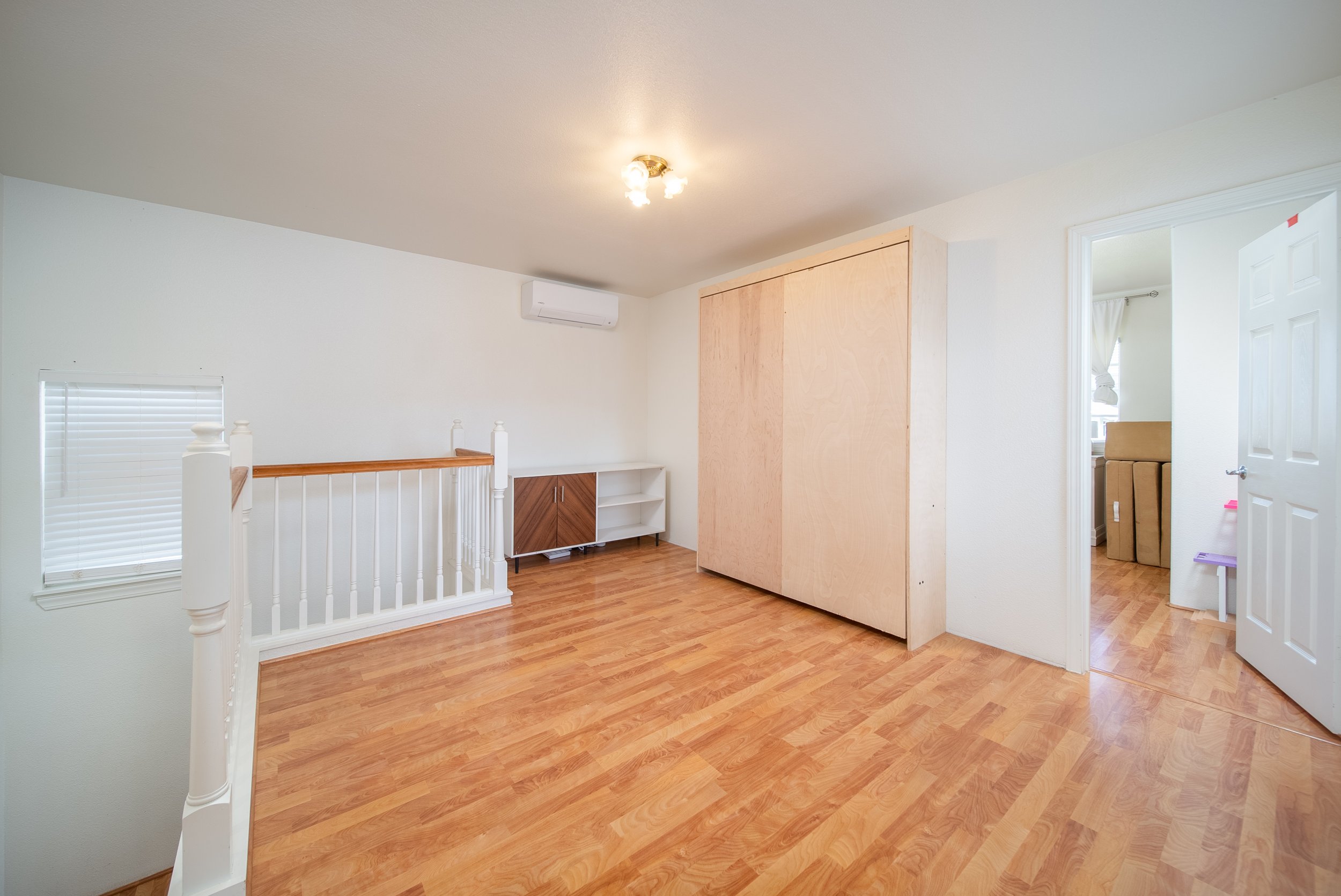 Upstairs landing with closet doors and hall bathroom, wood floors throughout