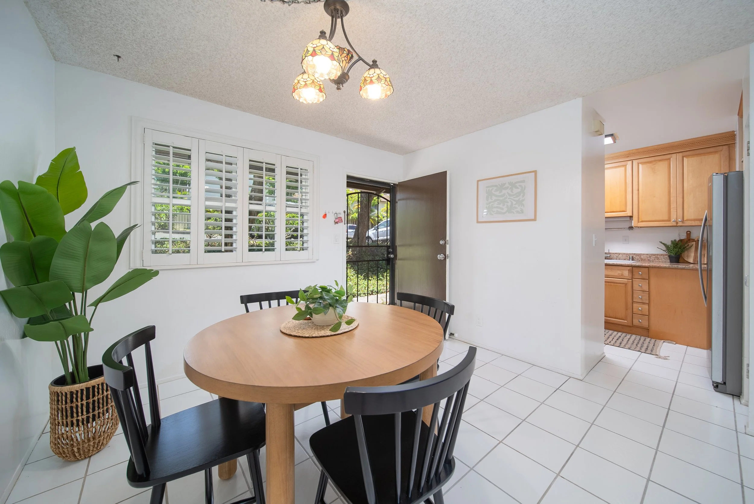 Dining area with plantation shutters and the kitchen just beyond