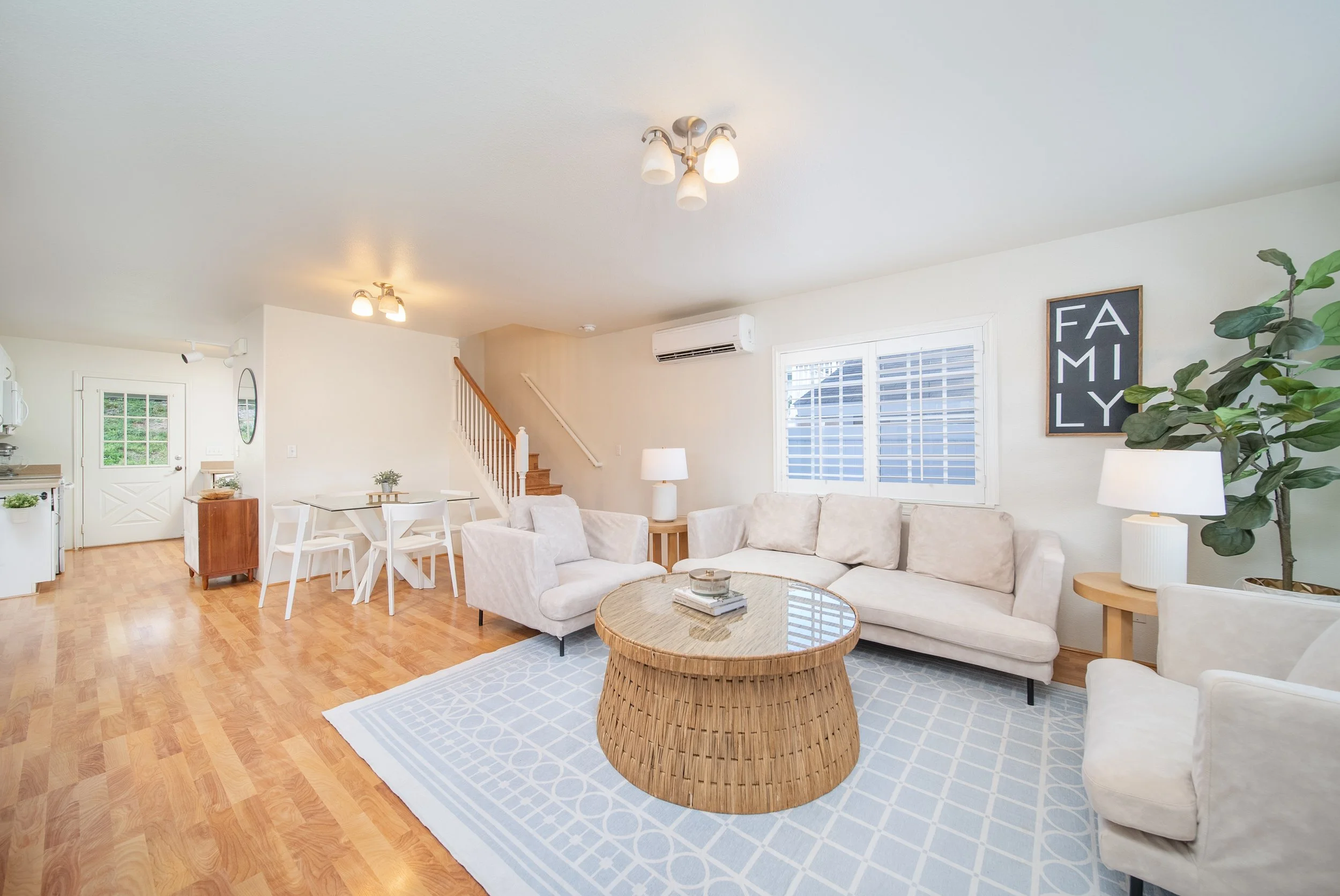 Living room with white sectional, round coffee table and dining area beyond, Maili Sea Palekai