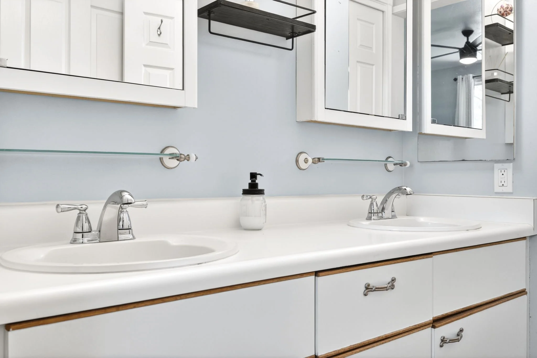 Primary en suite bathroom with two vanity sinks and mirrors