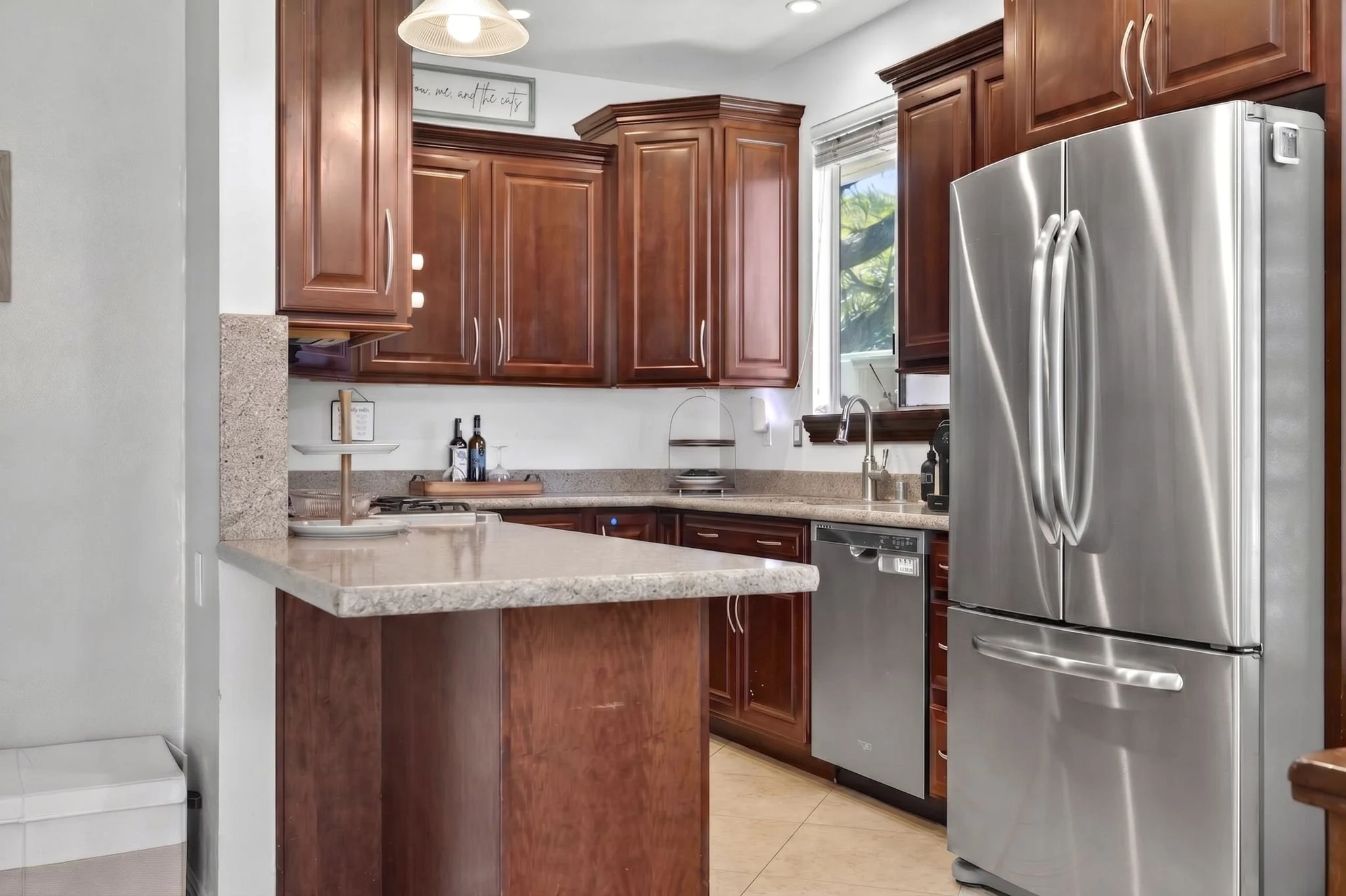 Kitchen with cherry cabinetry, granite counters and stainless refrigerator
