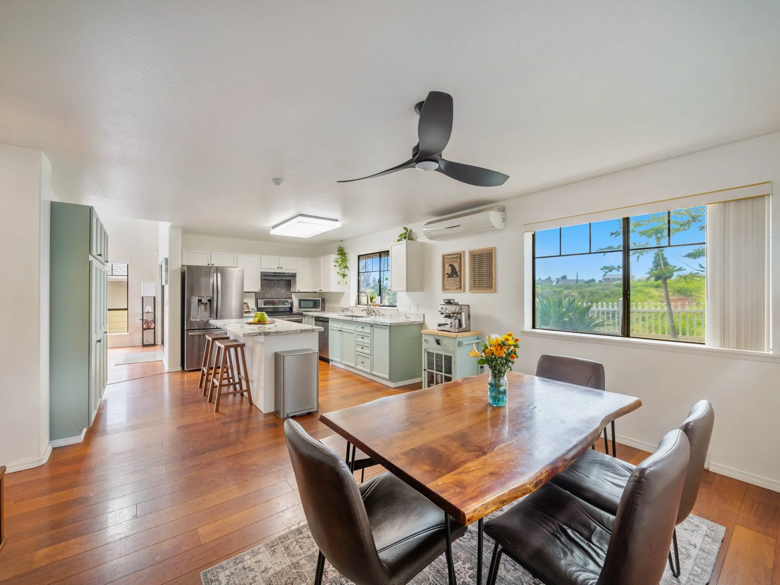 Dining area open to the kitchen with island, stools and window light