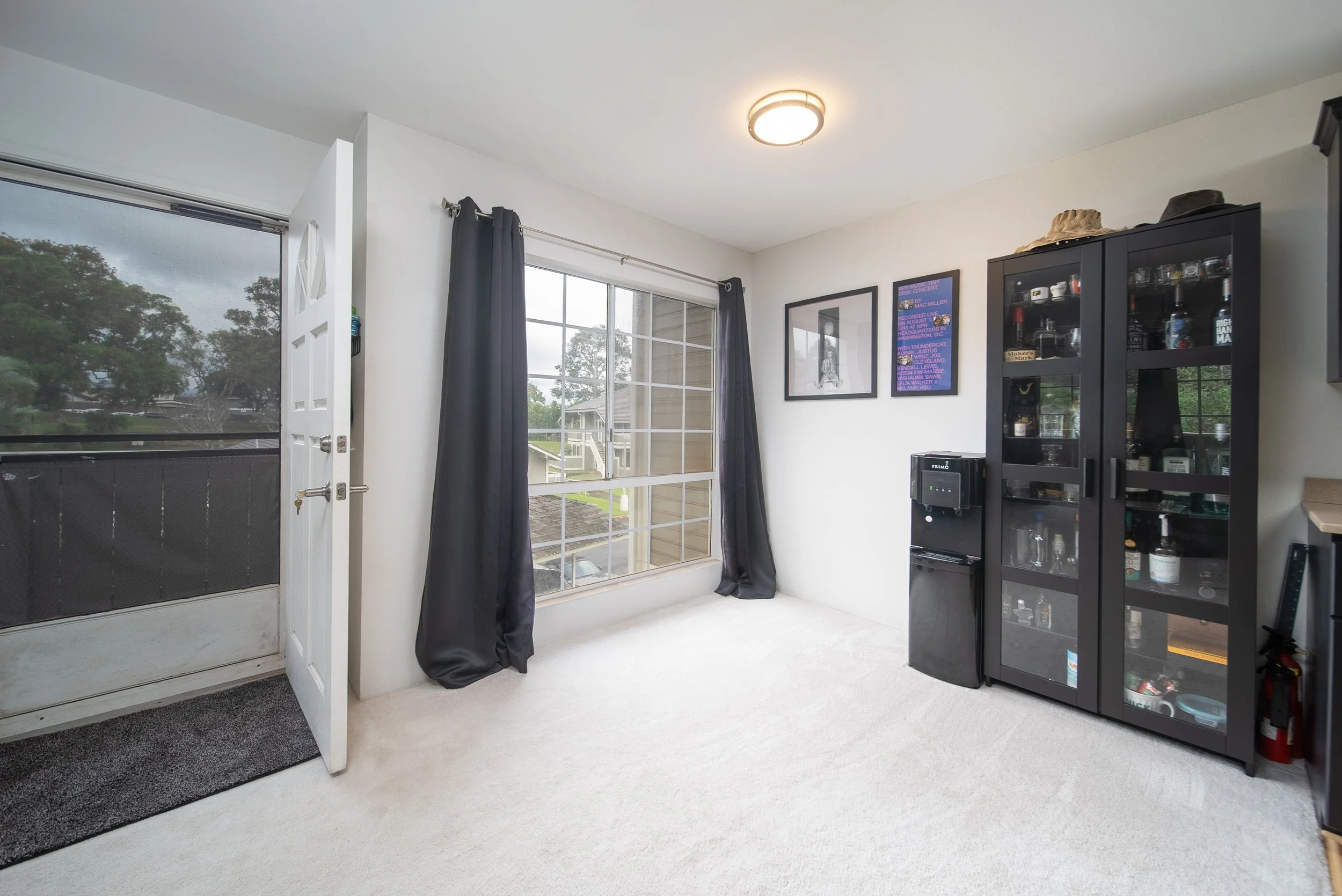 Living area with entry door, oversized window and display cabinets