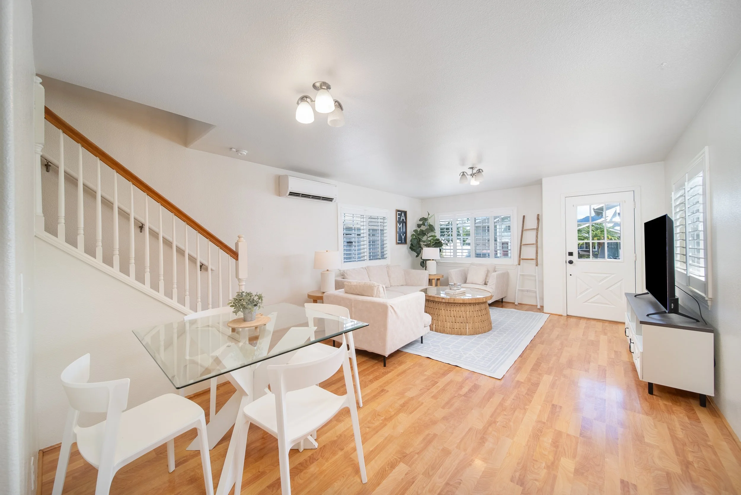 Open living and dining area with staircase, front entry and wood floors