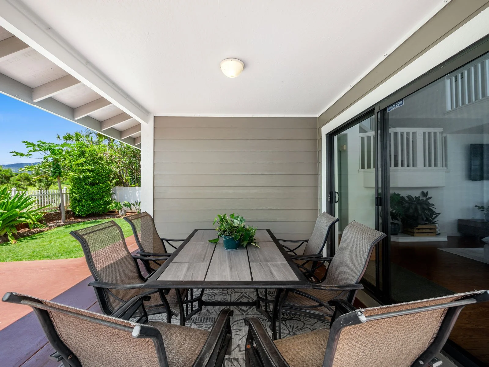 Covered lanai with dining set beside the slider into the living room
