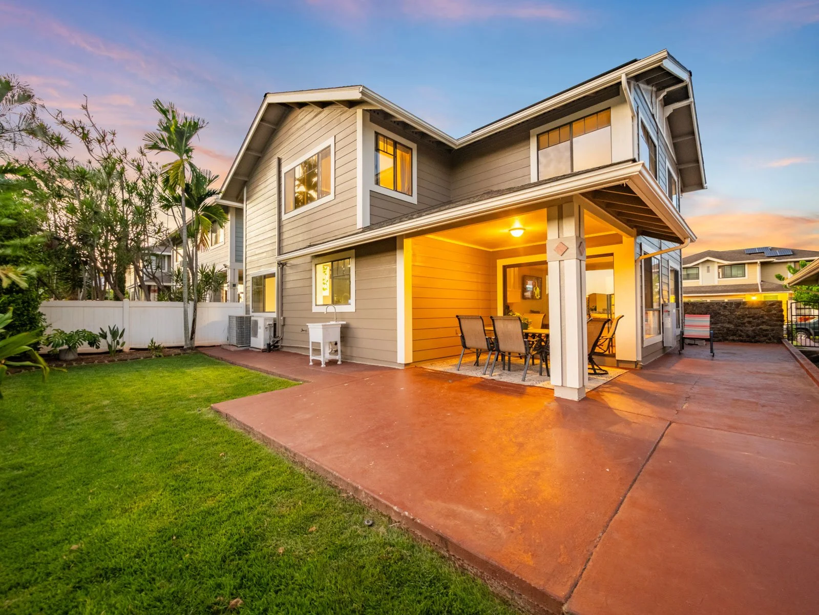Twilight rear exterior with covered lanai, stamped patio and green lawn, Royal Kunia Waipahu
