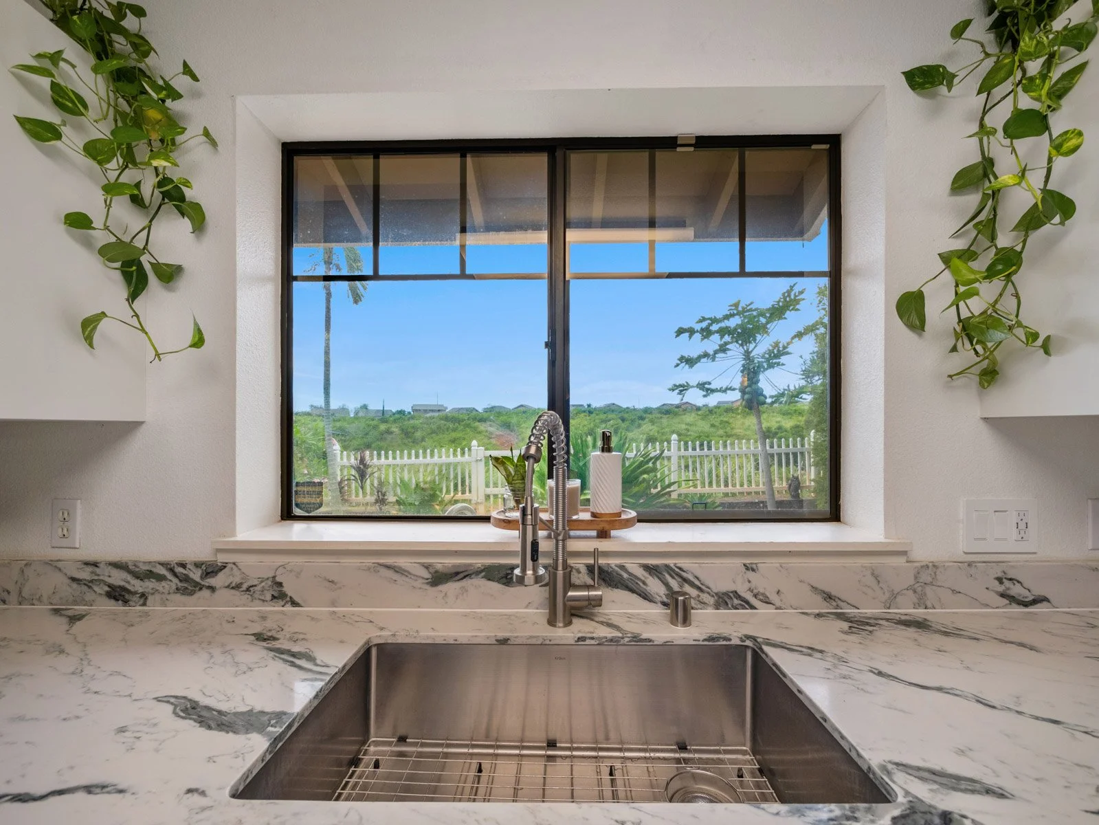 Undermount sink below the kitchen window looking out to the fence line