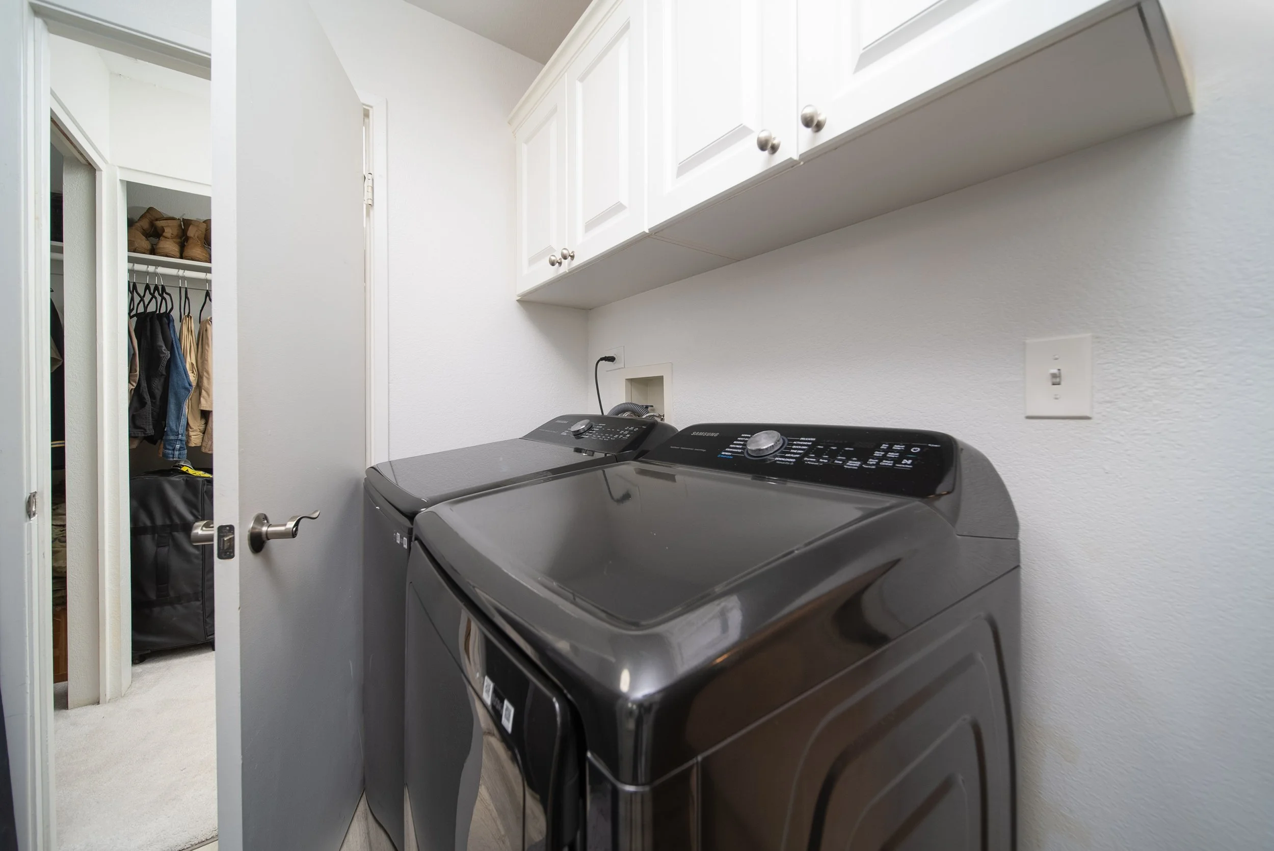 Full size washer and dryer inside the unit with storage cabinets above
