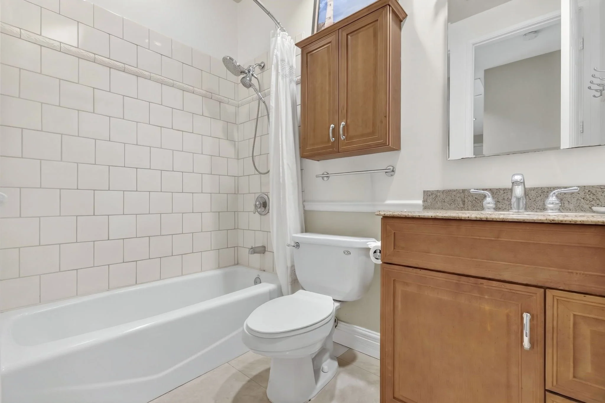 Bathroom with tub and shower, wood vanity and mirror