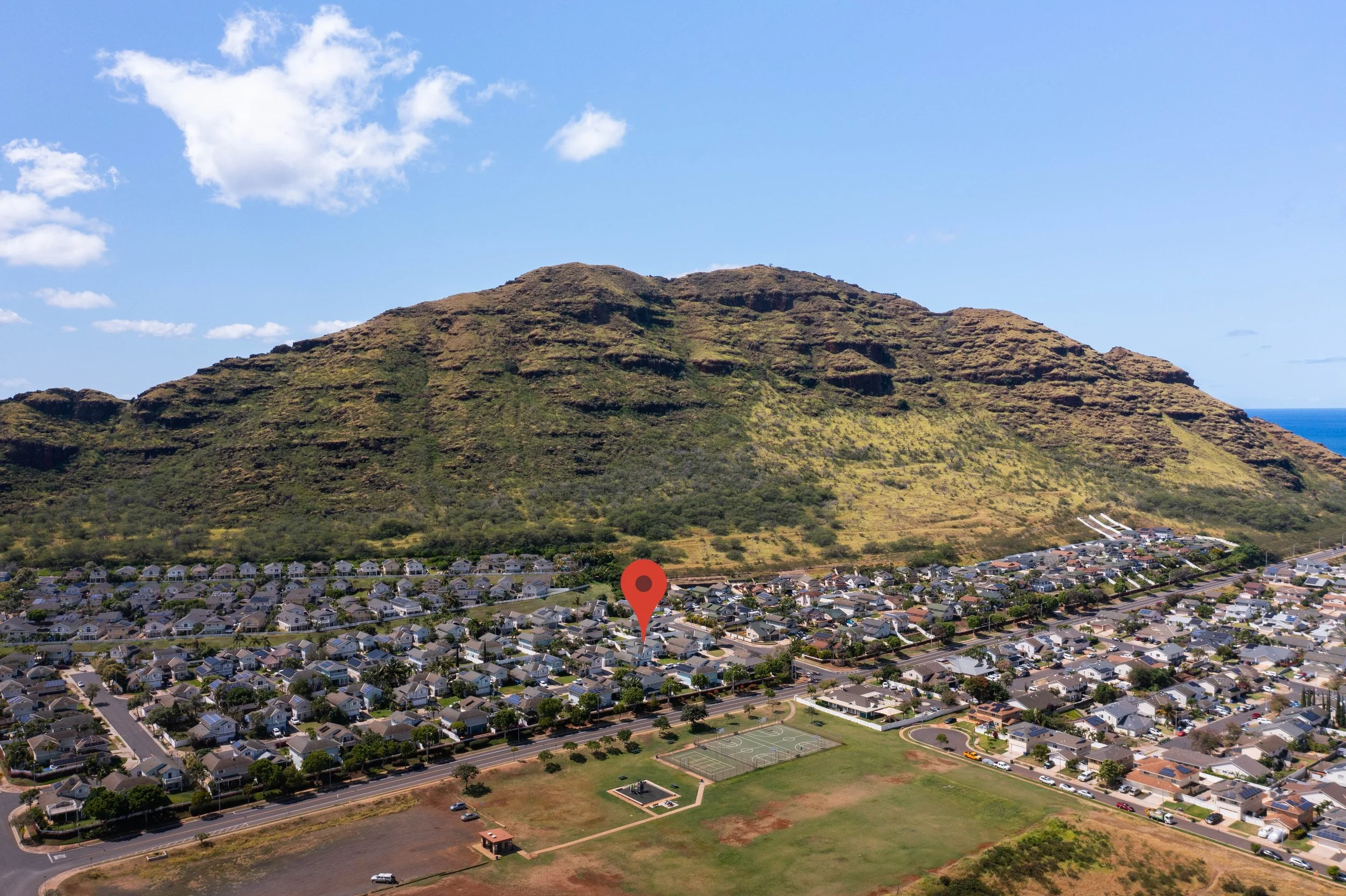 Aerial view of the neighborhood with the mountain ridge and ocean beyond