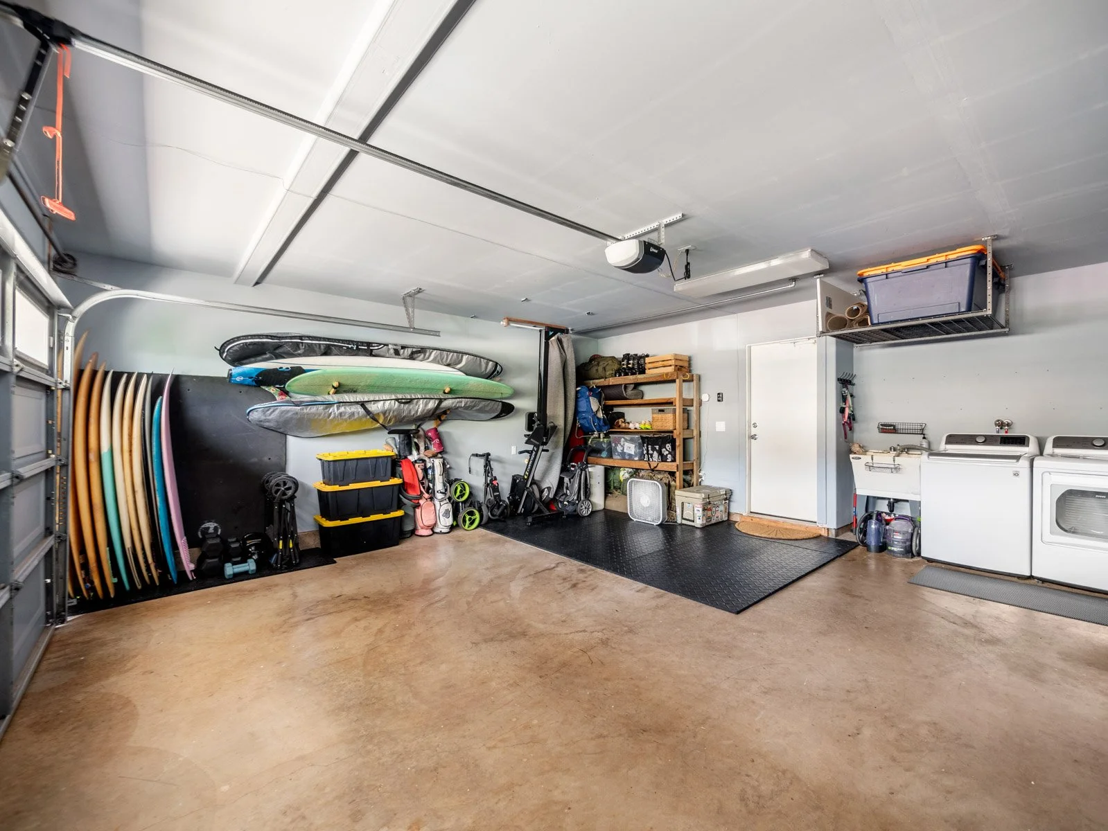 Garage with board racks, storage shelving, washer and dryer