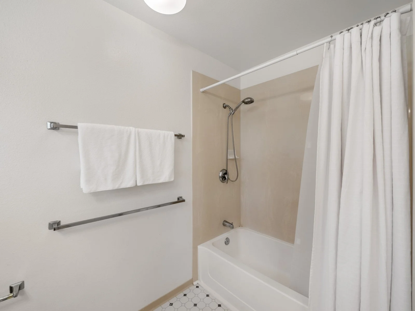 Bathroom with tub and shower, curtain and towel bars