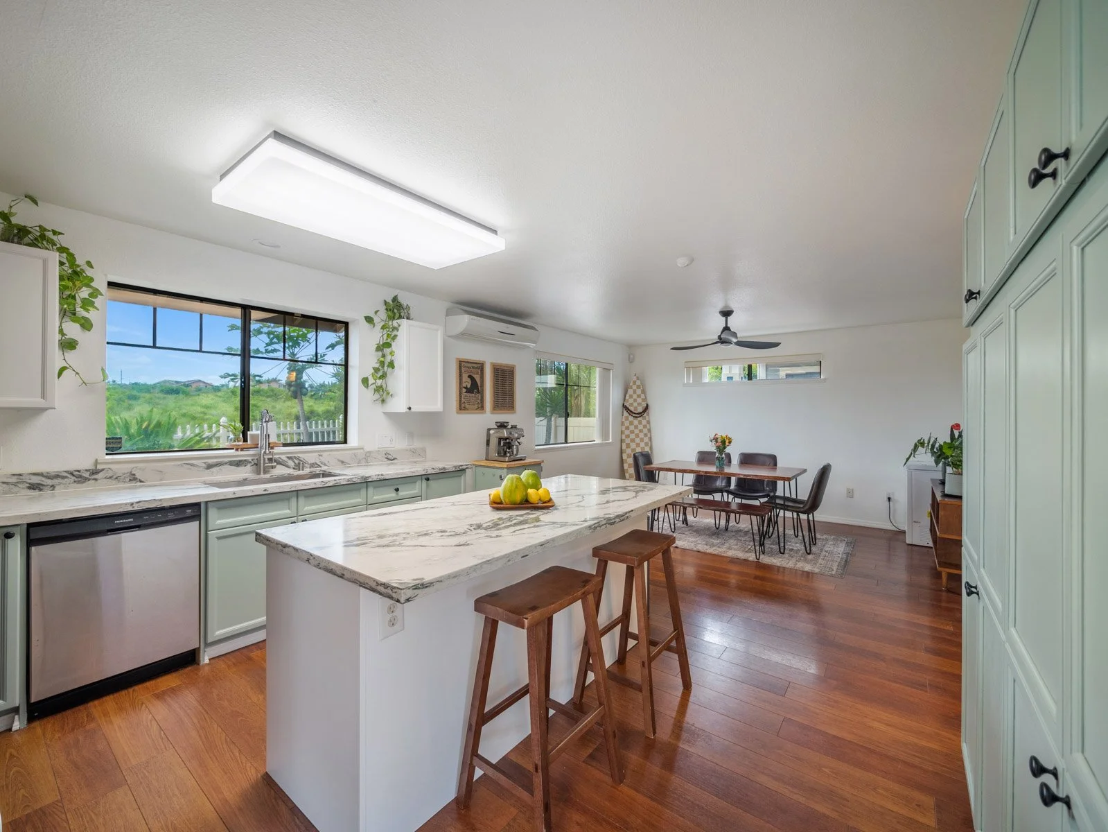 Kitchen with center island, stools, stainless appliances and sage cabinetry