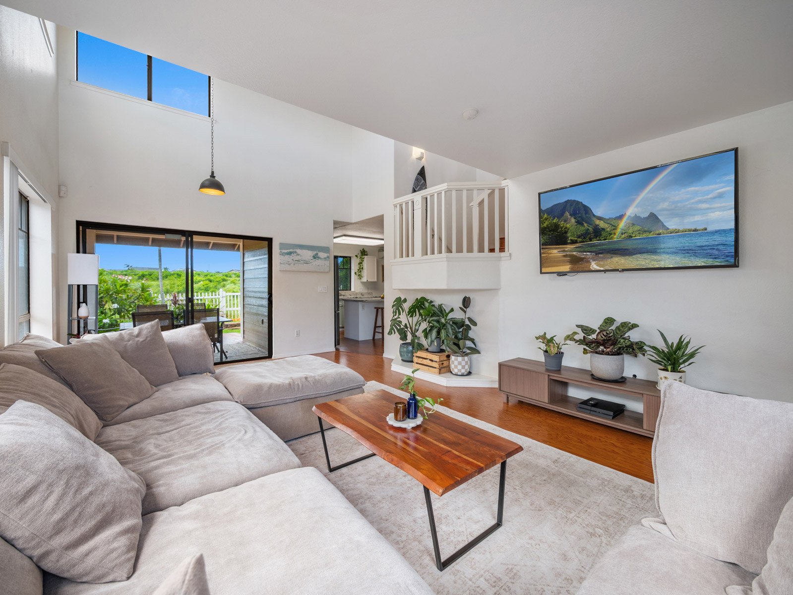 Living room with sectional, slider to the lanai and television wall