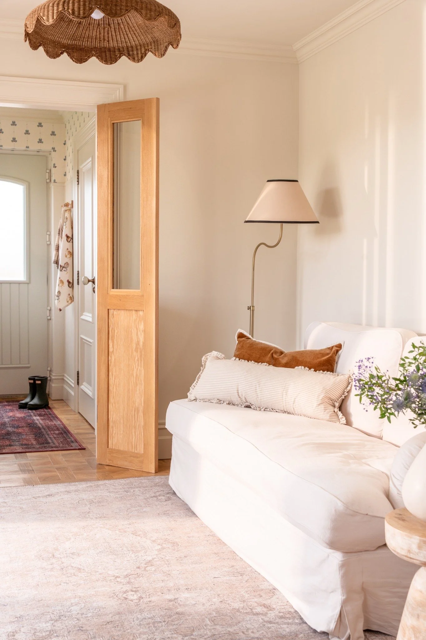 White sofa, layered cushions, warm timber and soft lighting at Warrenpoint Residence.