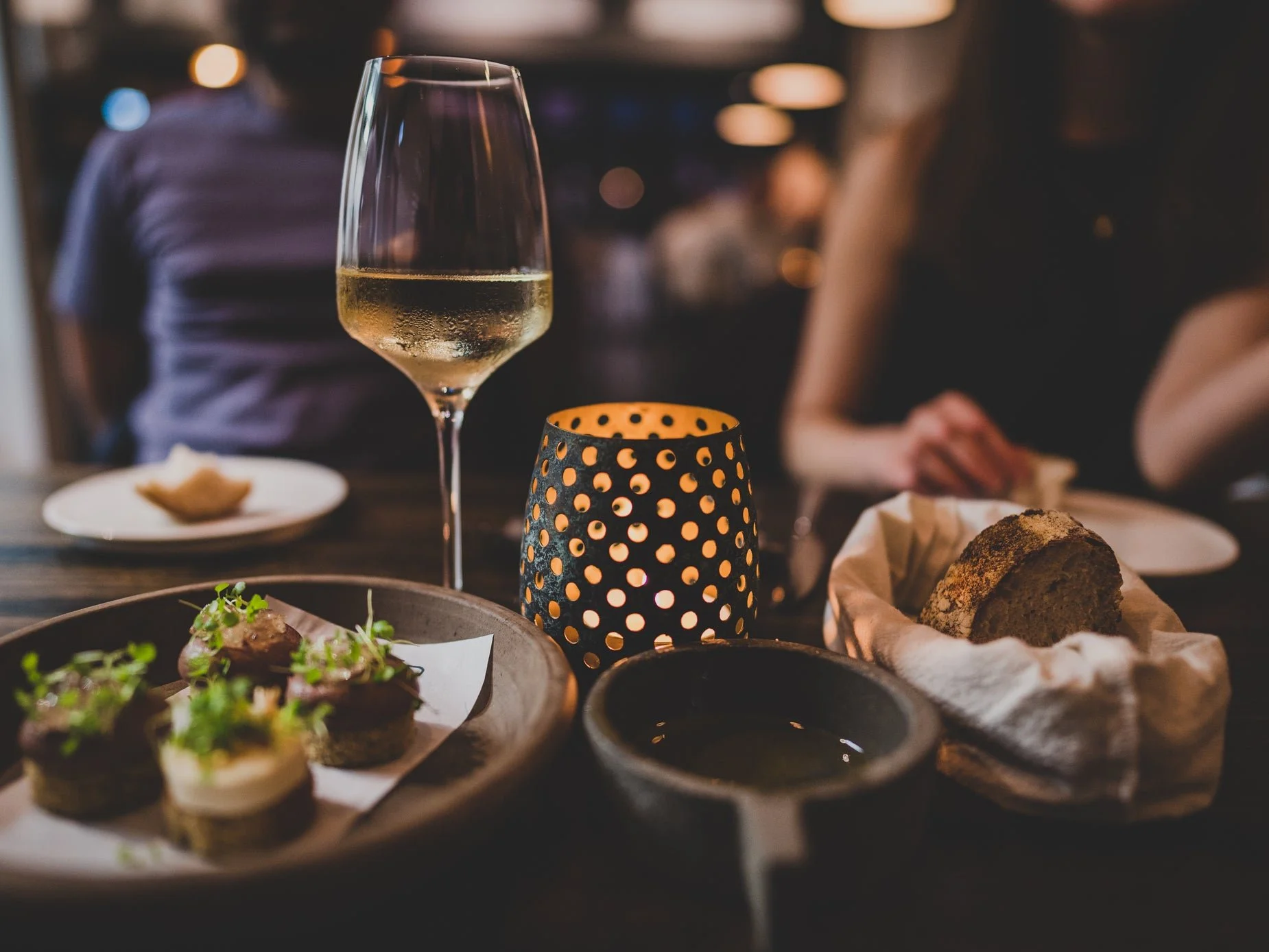 Warm candlelight and fine glassware around an intimate dinner table