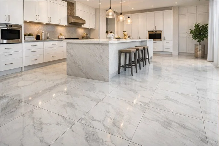 Light marble-look kitchen tile floor around a central island and white cabinetry