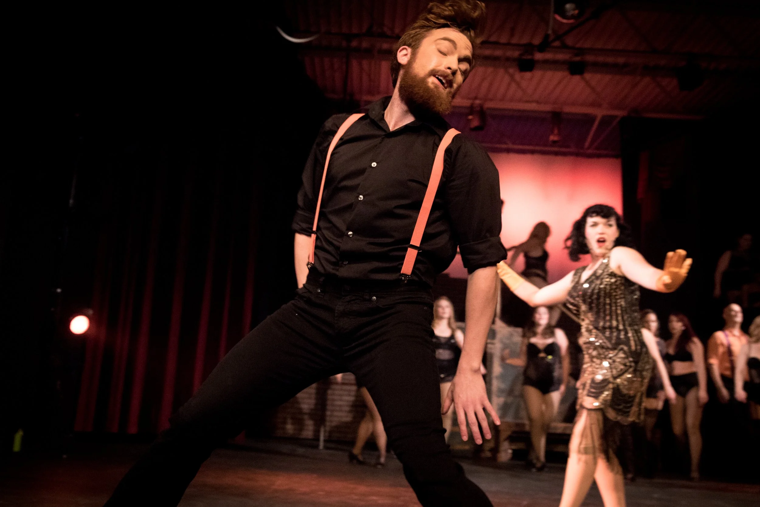 Dancer in suspenders mid-step during a jazz performance