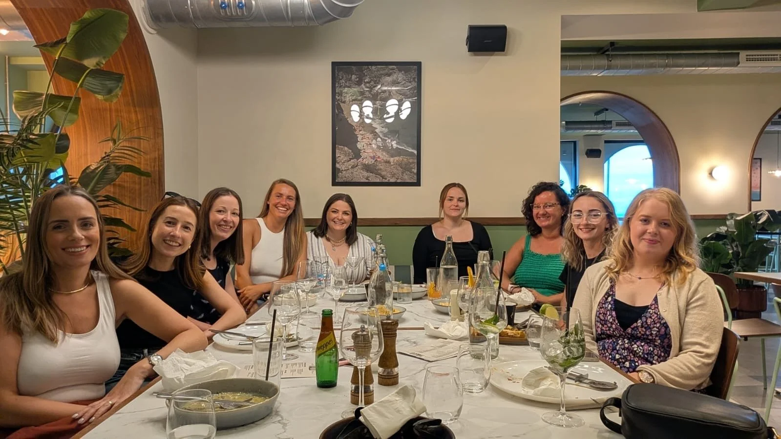 Dreckly Wild Women members round a long table at a supper club