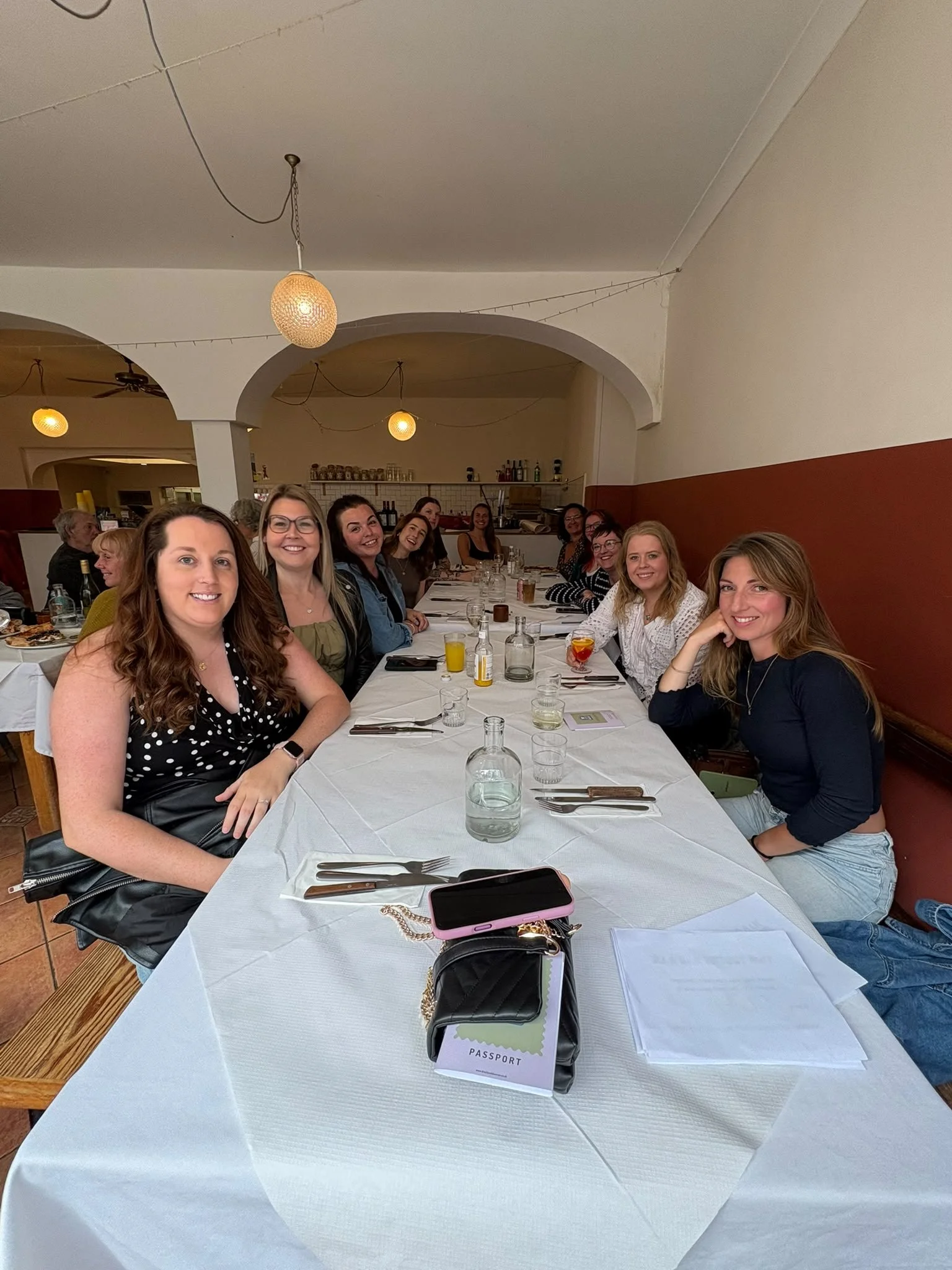 Dreckly Wild Women members round a long table at a supper club