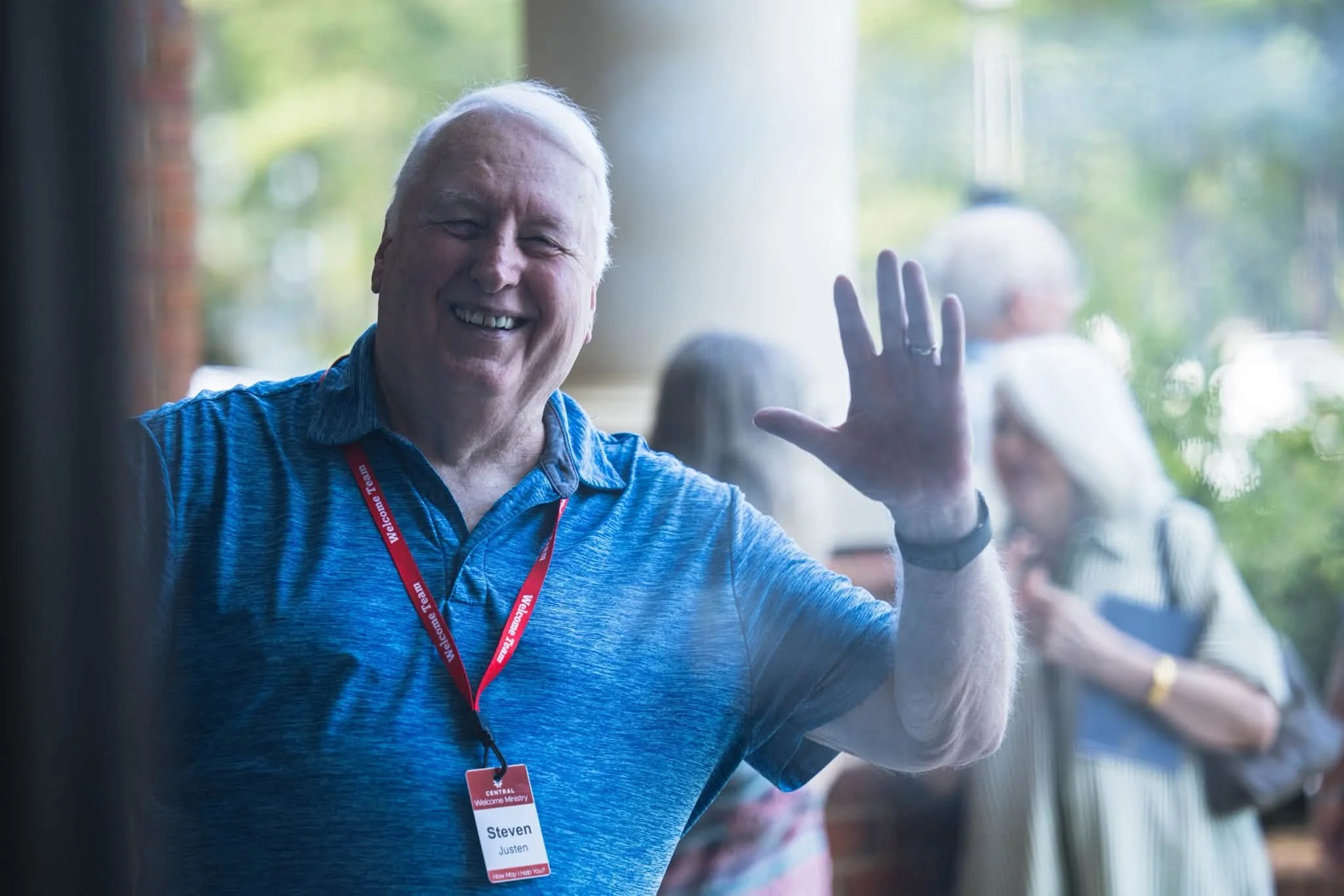 A smiling senior adult waving at Central Baptist Church