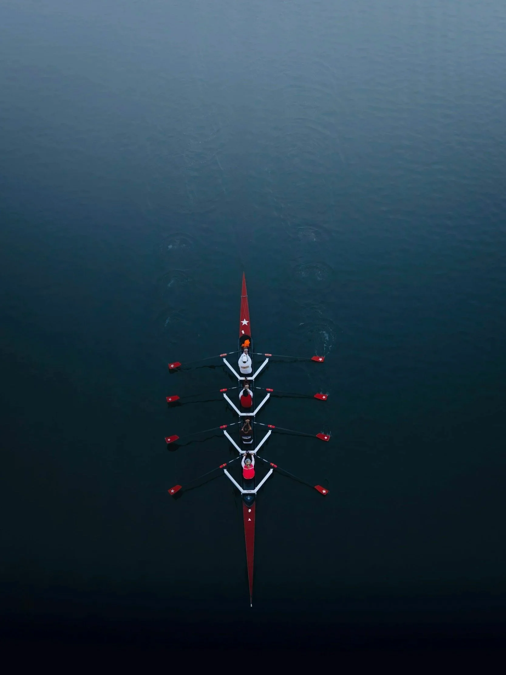 Overhead view of rowing team on deep blue water