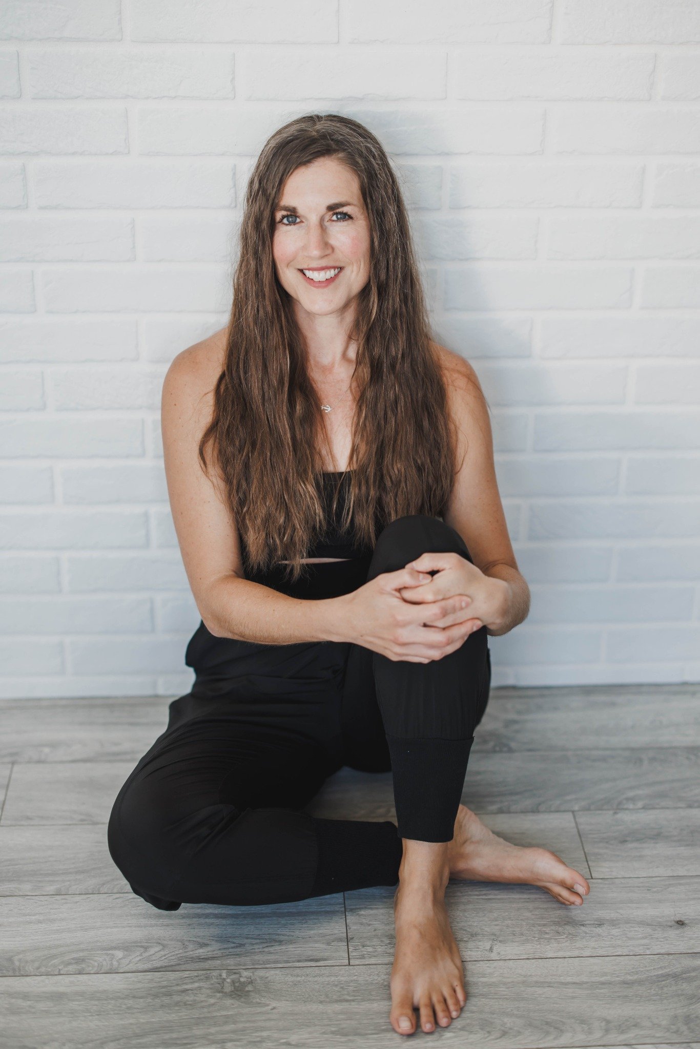 Andrea Carow smiling while sitting comfortably on the floor