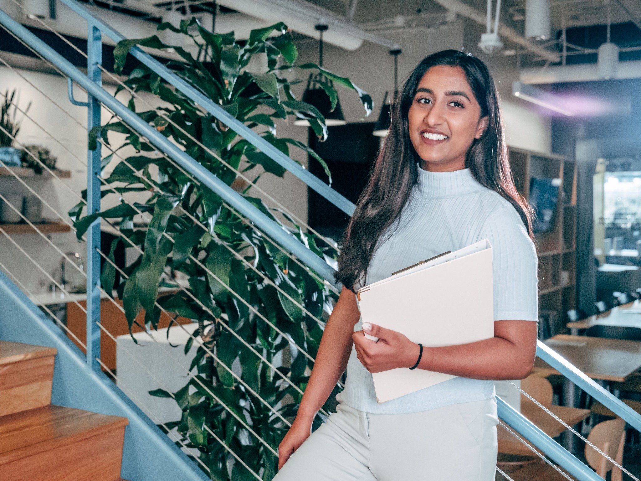 Young adult holding a folder in a workplace