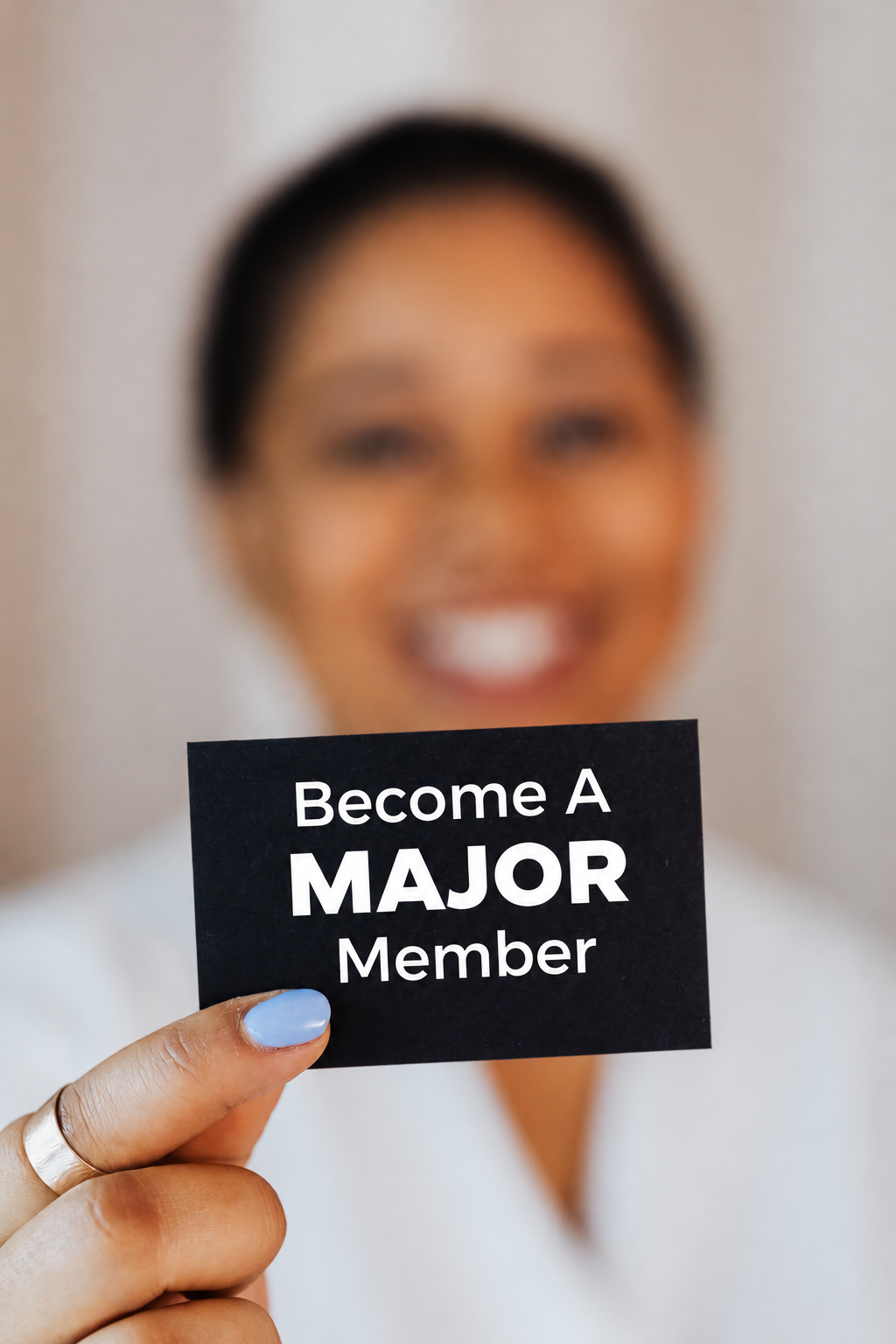 Woman holding a black card that reads Become A MAJOR Member