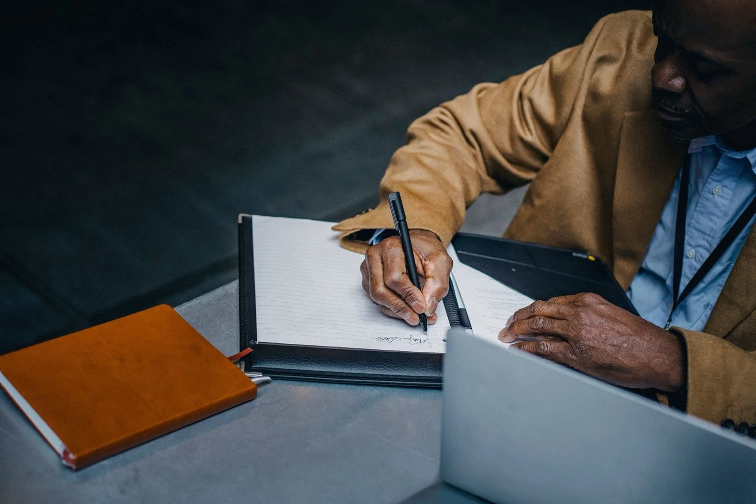 An entrepreneur writing a plan beside his laptop