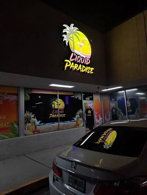 Liquid Paradise storefront at night