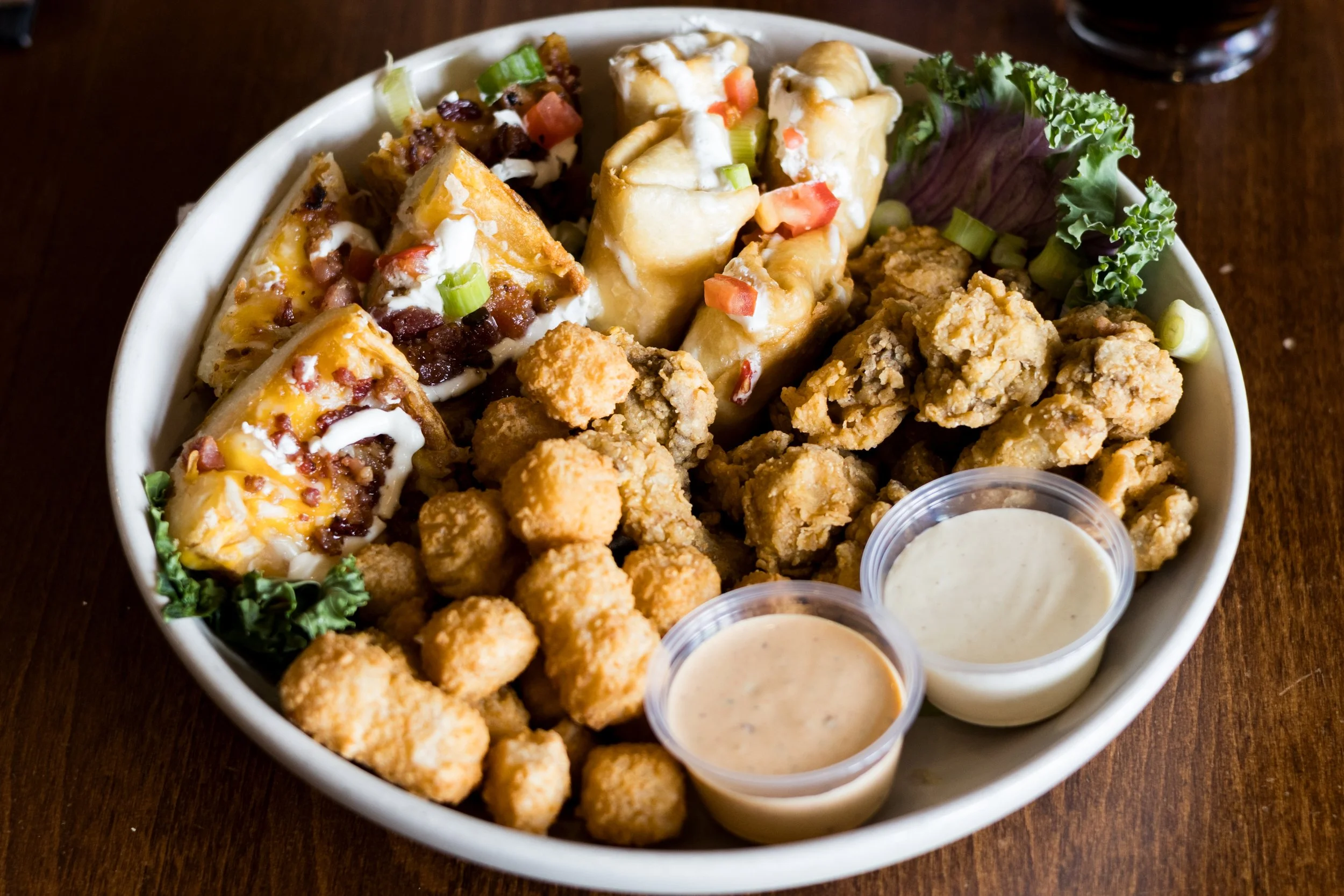 Sampler including breaded mushrooms, jack bites, potato skins, and southwest egg rolls from Walt’s Pub & Grill in West Lafayette