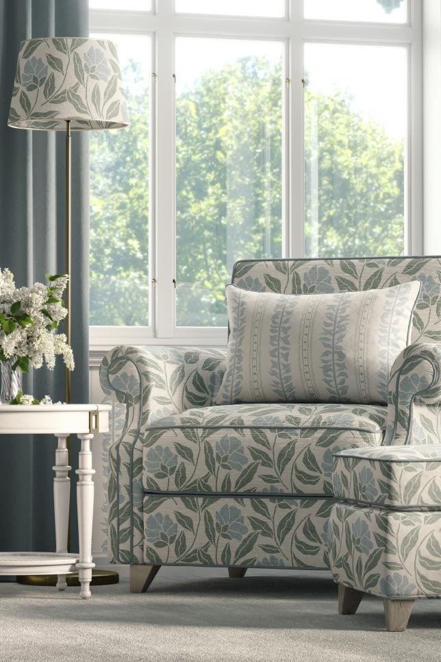 Elegant reading chair and ottoman upholstered in the Brielle botanical floral, styled with a matching lampshade in a light-filled traditional interior.