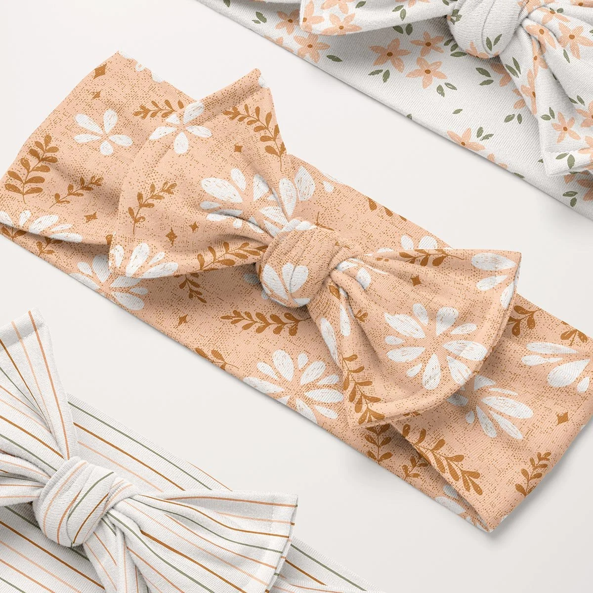 Cute boho floral seamless pattern design featured on coordinated baby accessories, nursery textiles and children’s products.