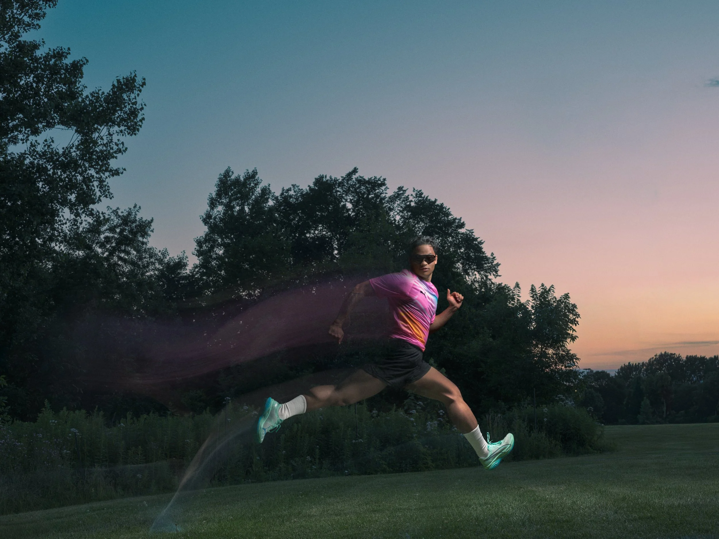 PUMA running campaign photograph of an athlete jumping at dusk with a controlled motion trail