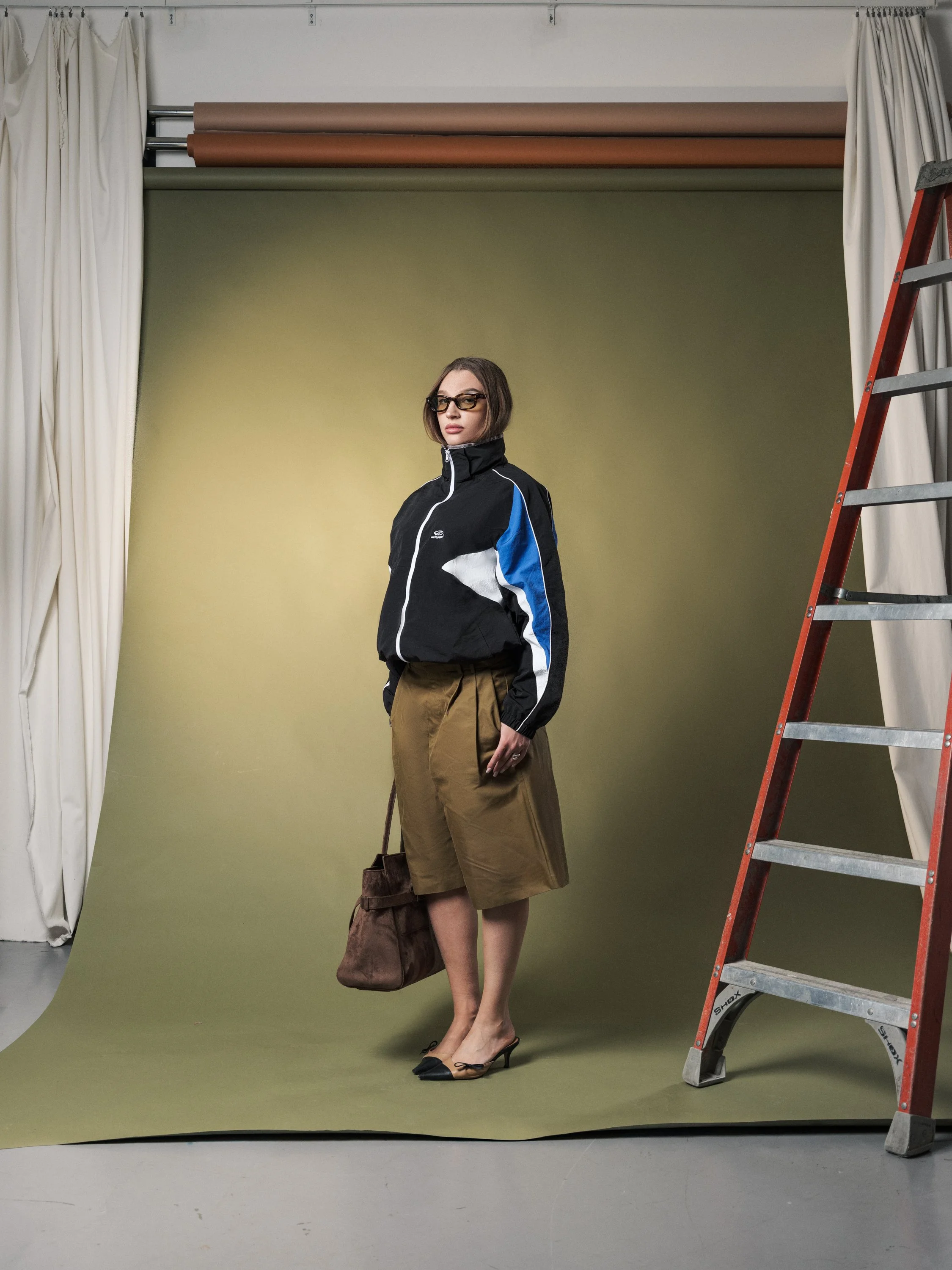 Vanity Apparel advertising image of female model standing against green studio backdrop