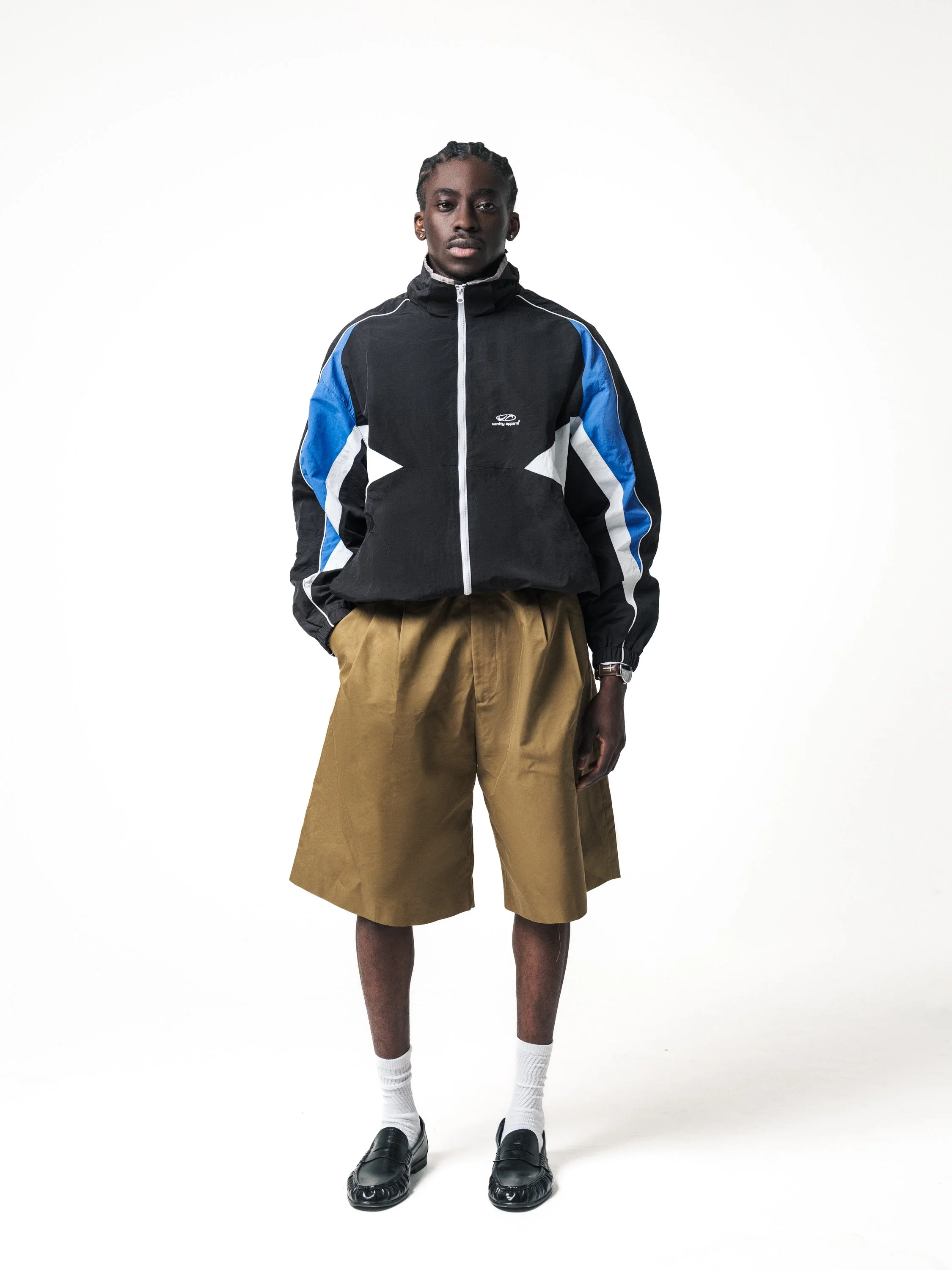 E-commerce fashion image with male model in front view wearing black jacket and tan shorts