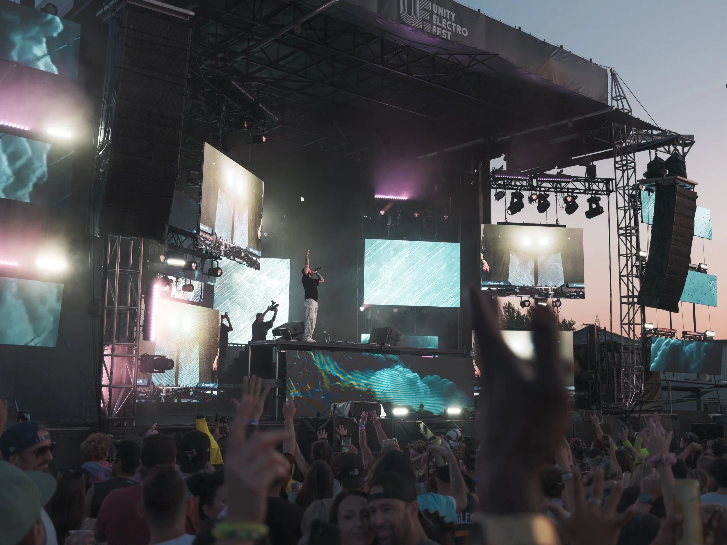 Atmospheric event photograph from Unity Festival with stage lighting, crowd energy, and nightlife ambience