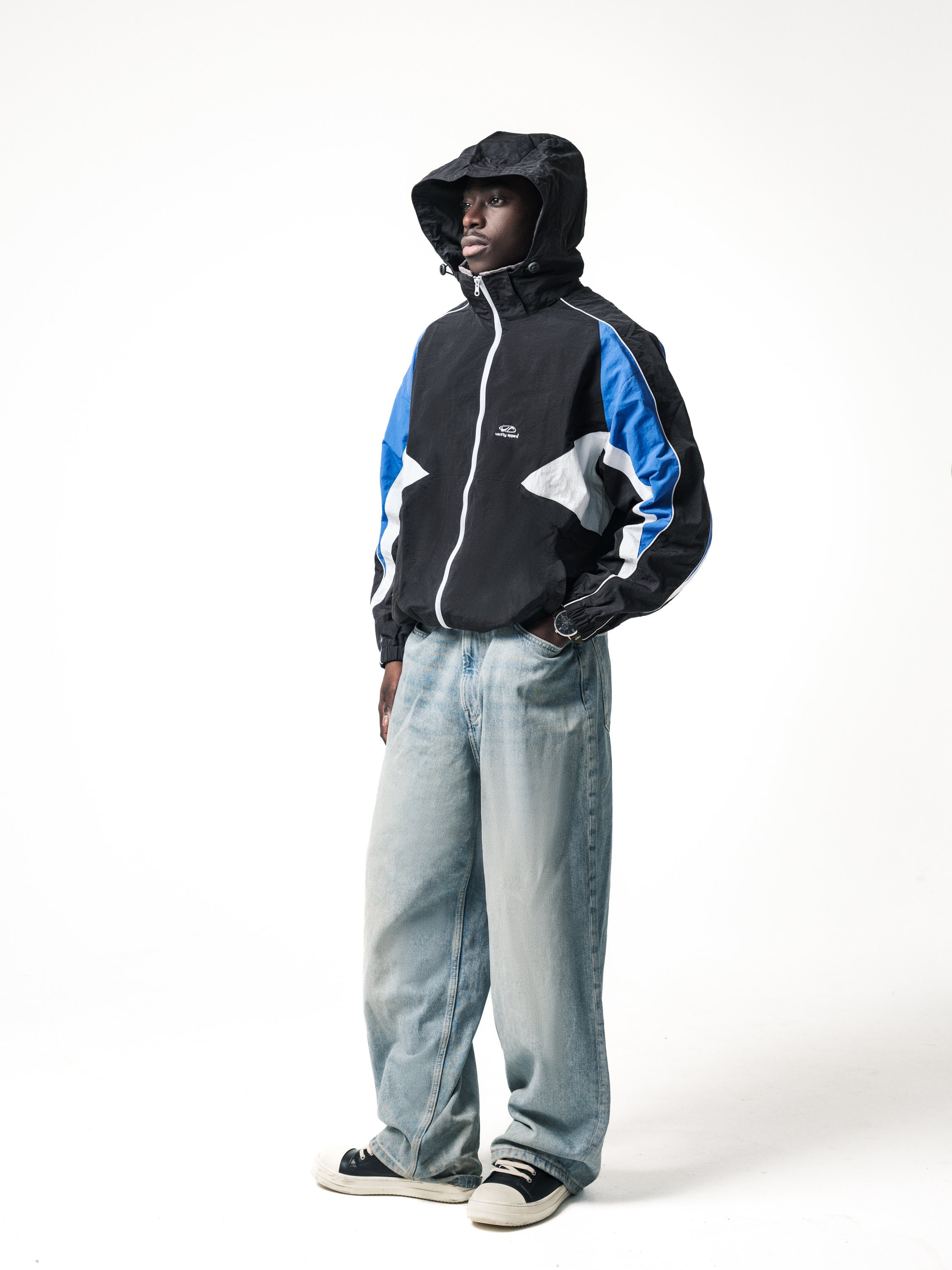 E-commerce fashion image with male model in three-quarter view wearing hooded jacket and jeans