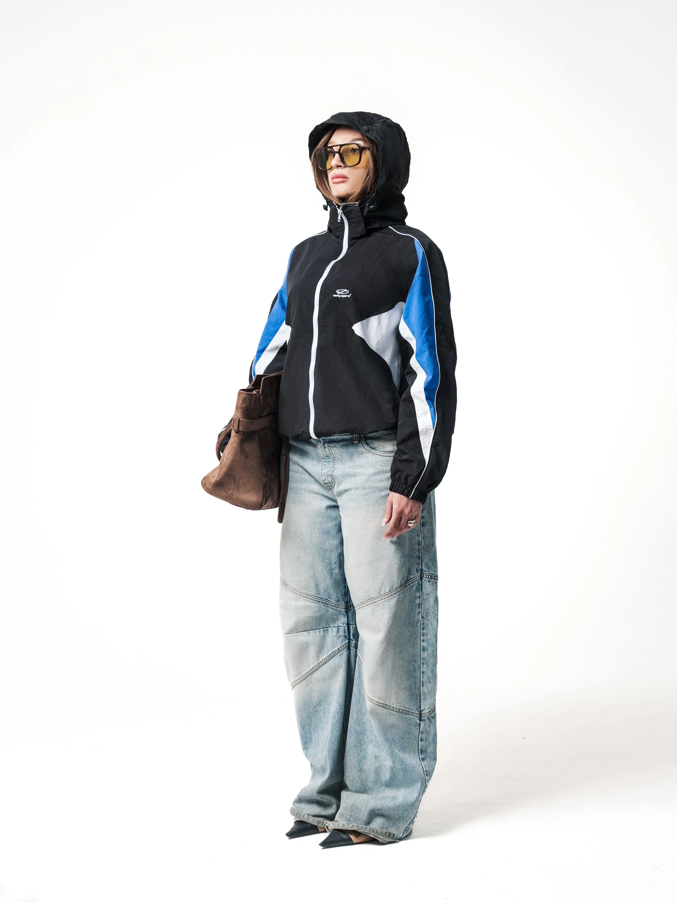 E-commerce fashion image with female model in three-quarter view wearing hooded jacket and jeans