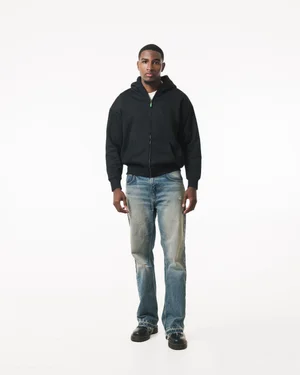 Full-length front view of a model wearing a black R3 CONCEPT zip hoodie and jeans