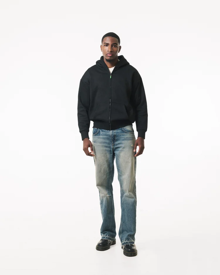 Full-length front view of a model wearing a black R3 CONCEPT zip hoodie and jeans
