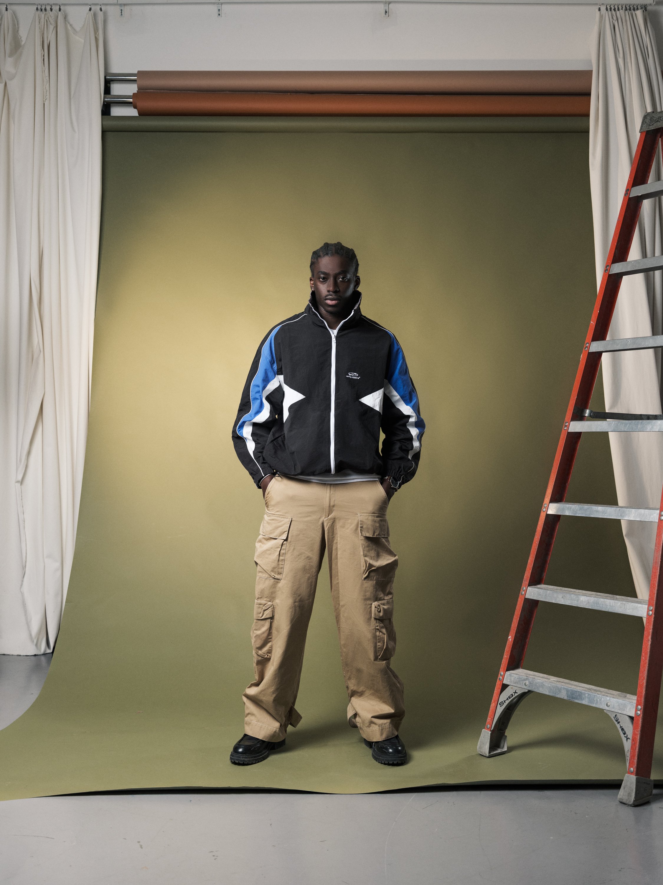 Vanity Apparel advertising image of male model standing front-facing against green studio backdrop