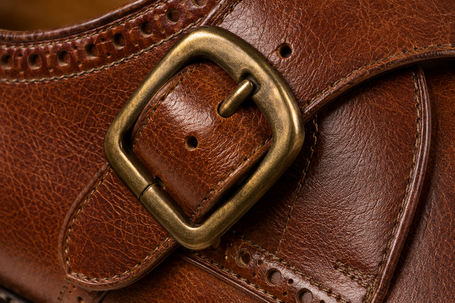 Antique-brass buckle over tan monk strap macro