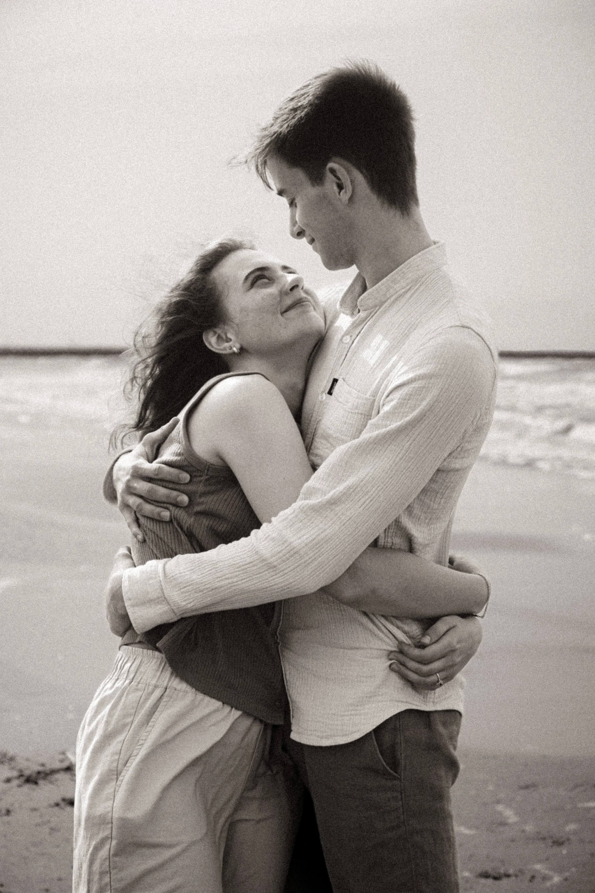 Portrait de couple enlacé en noir et blanc, photographie sensible au grain argentique, Marion David photographe Belgique