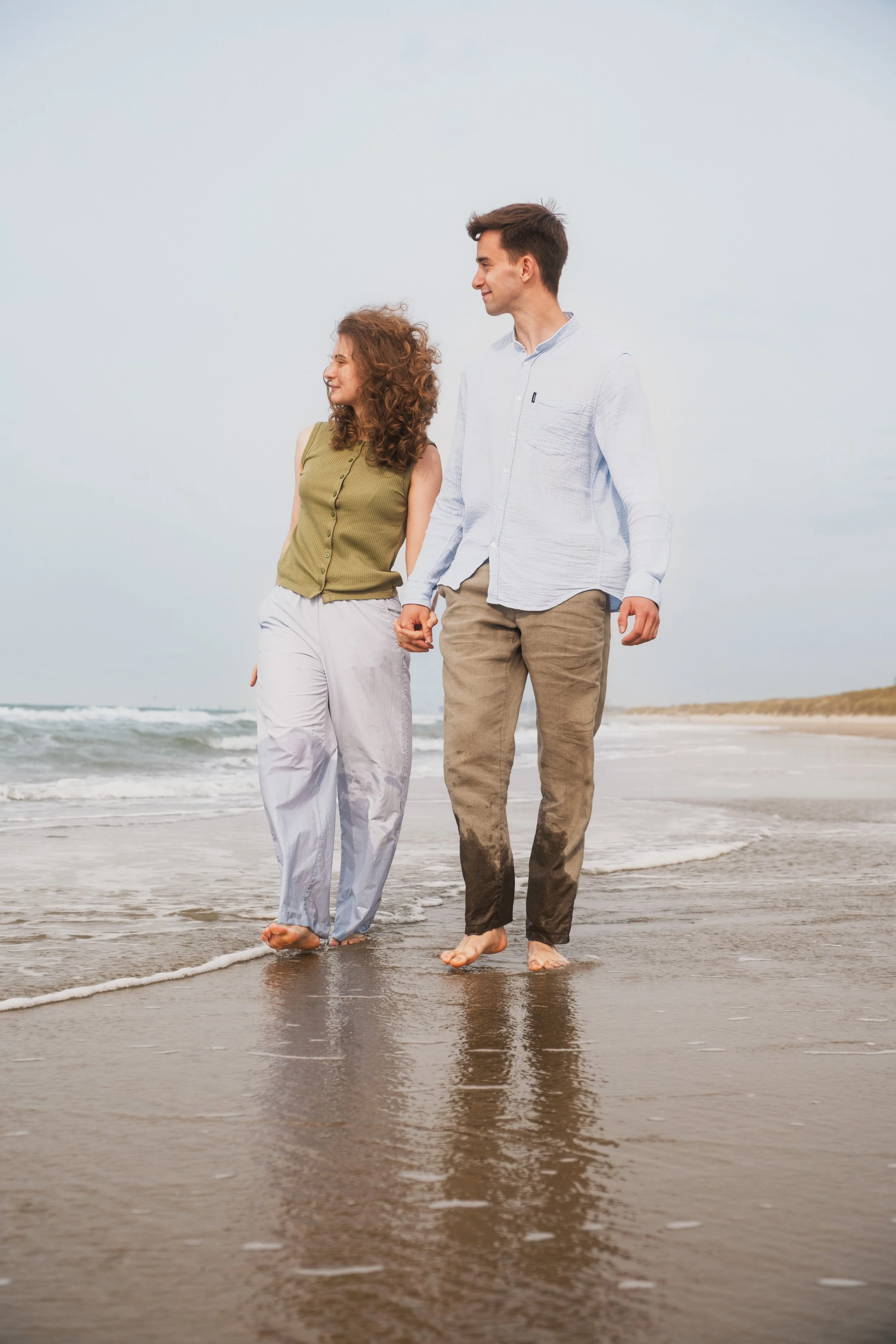 Couple main dans la main marchant au bord de l'eau, photographie de couple naturelle, Marion David photographe Bruxelles