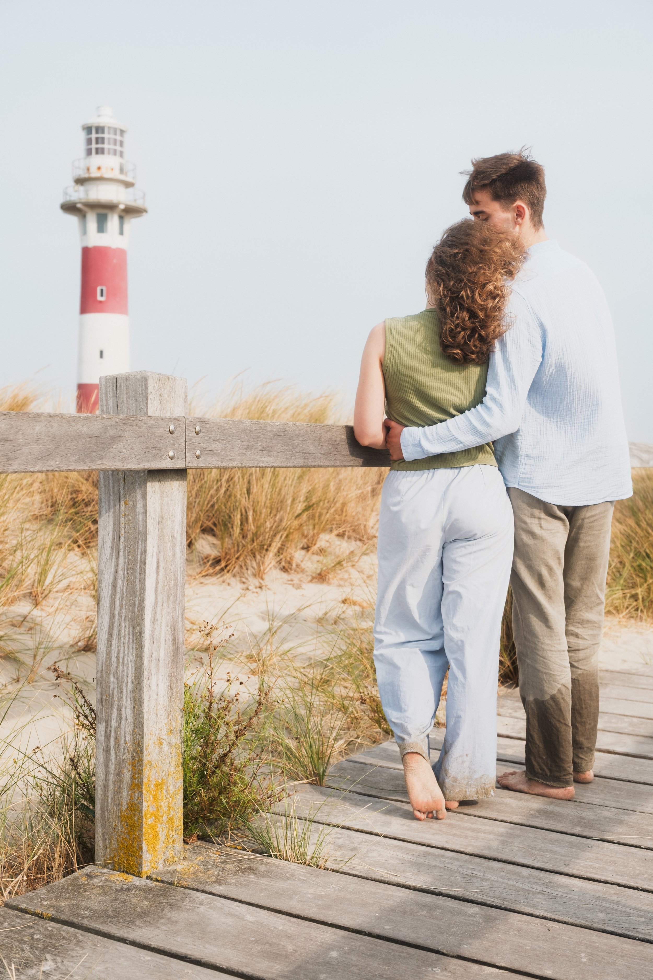 Couple enlacé face au phare de Nieuwpoort, séance photo couple sur la côte belge, Marion David photographe