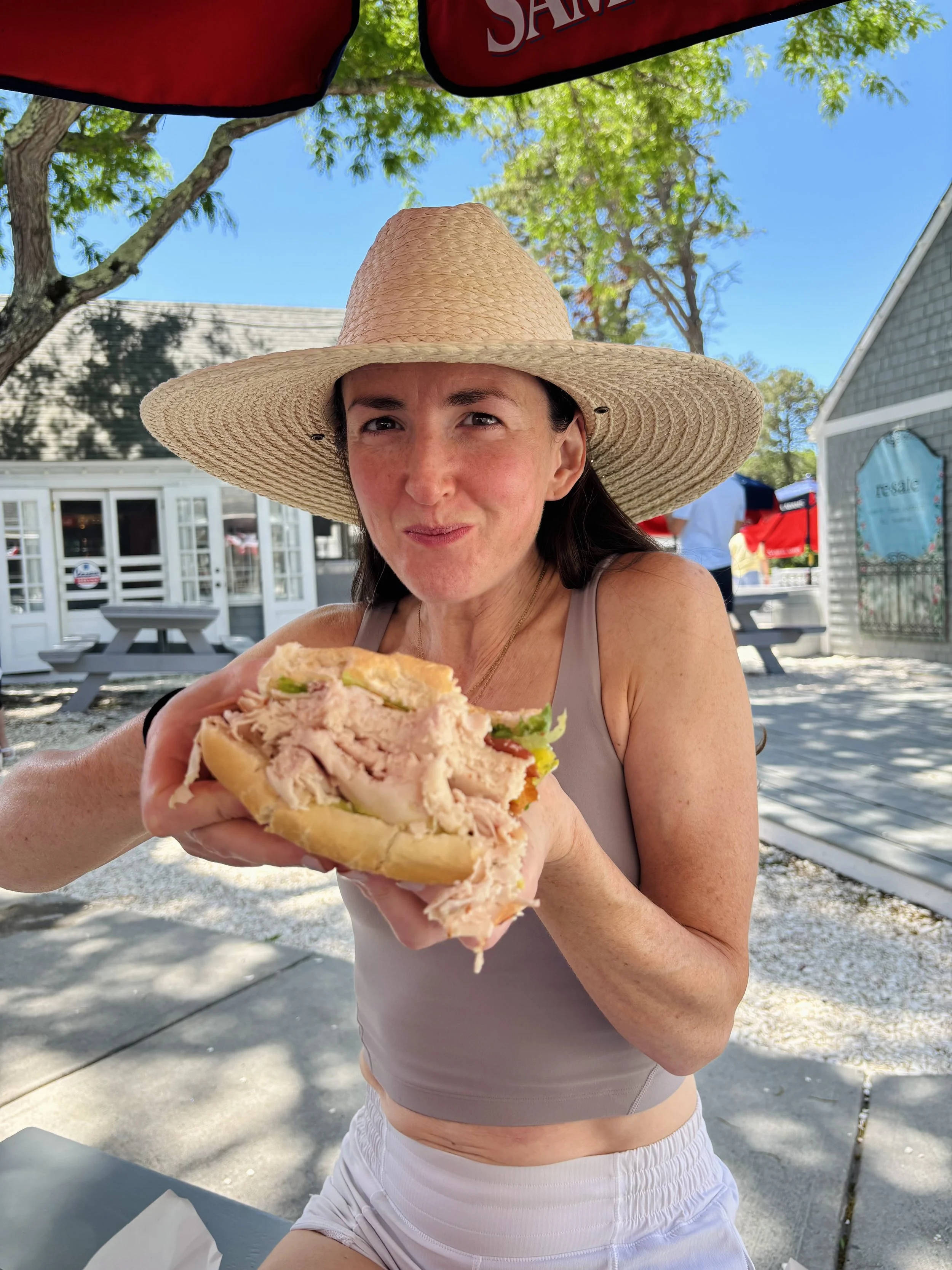 Registered Dietitian Claire Margolf eating a high-protein sandwich while traveling.