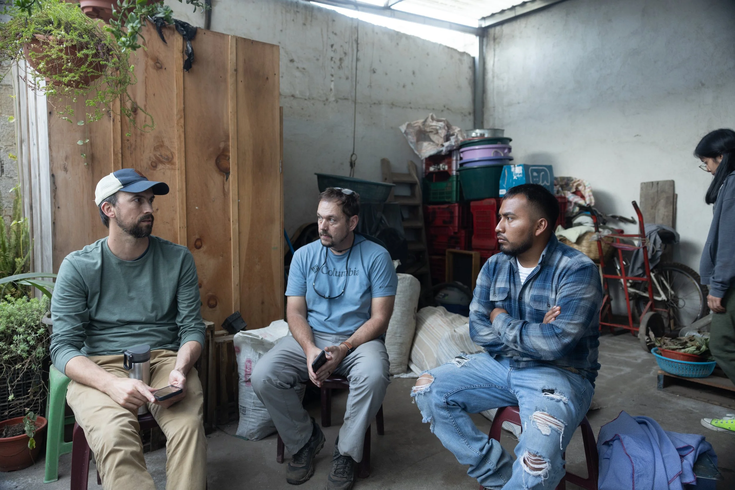 Vienna Coffee and Deeper Roots team members sitting and talking with a producer in Guatemala